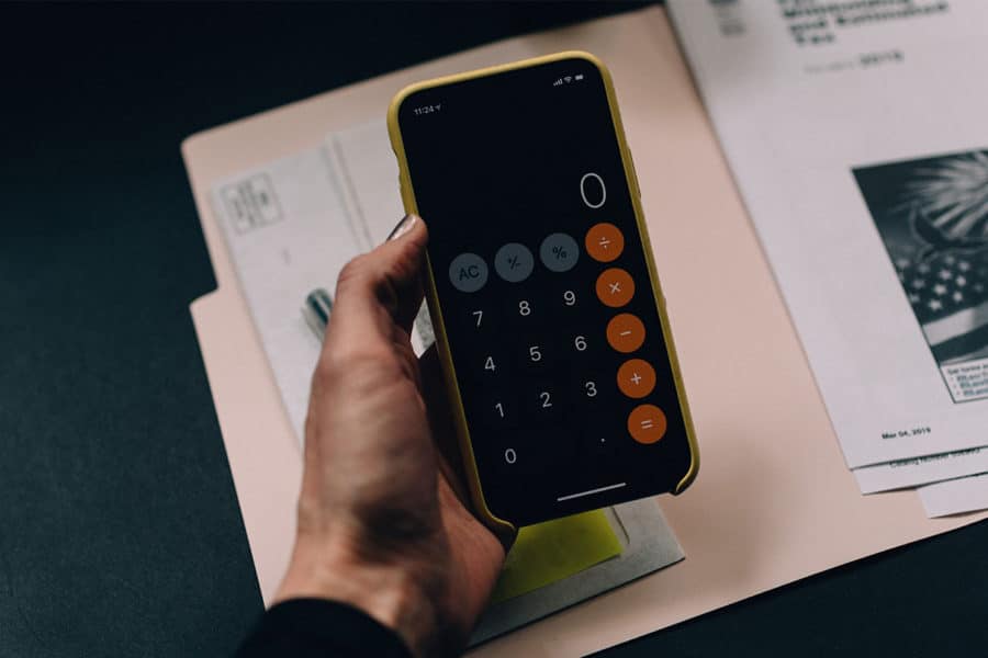 Billiger verschicken: Hand hält ein Smartphone mit Taschenrechner