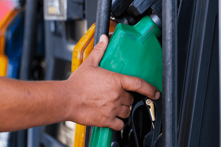 Corriere che fa rifornimento a una pompa di gasolio e benzina.