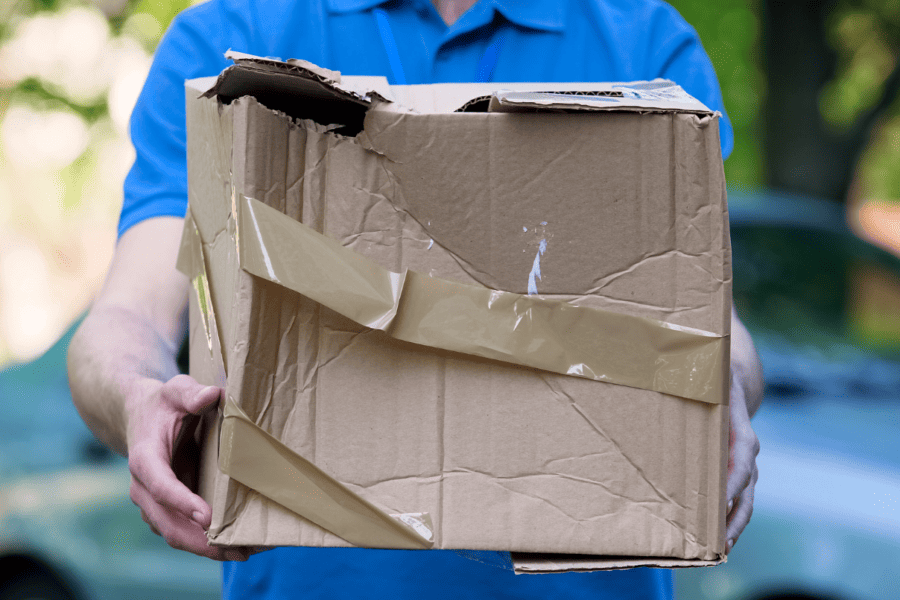 A deliveryman carrying a damaged parcel