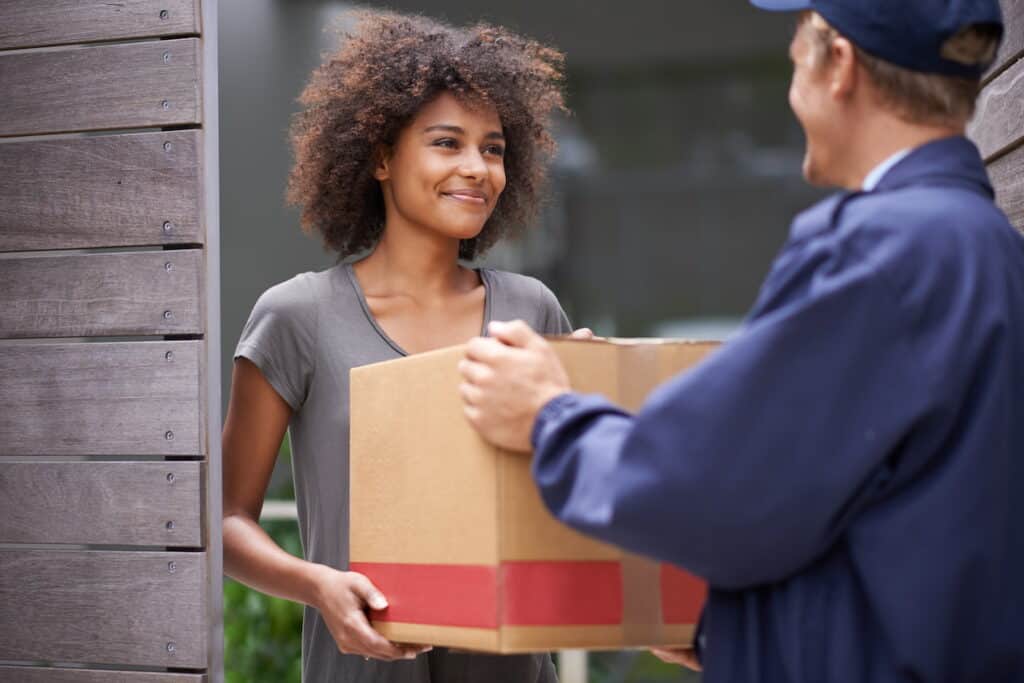 Delivery person and woman happy with parcel