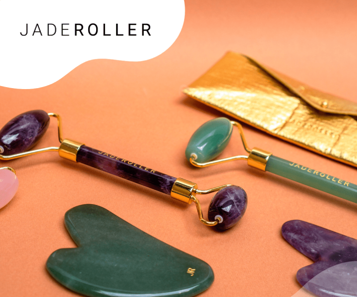 Jade facial rollers and gua sha stones on a peach background, with text "JADEROLLER".