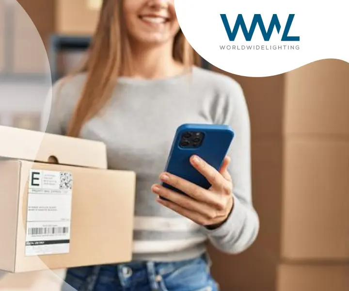 A person holding a smartphone and a package with the WorldWideLighting logo